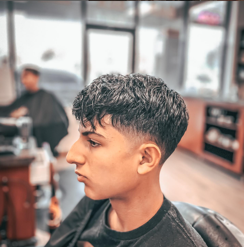 man in barbers chair getting hair cut